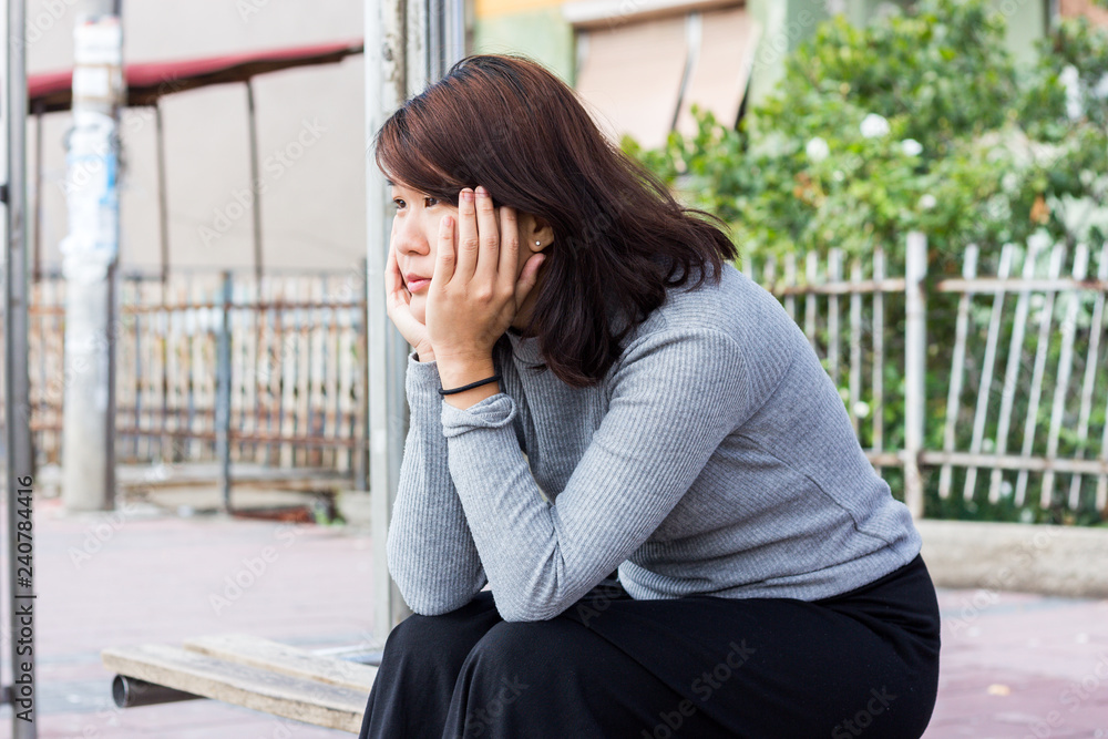 Chinese Girl Sitting on the Bench and Thinking While Waiting For Someone Chinese Girl Sitting on the Bench and Thinking While Waiting For Someone