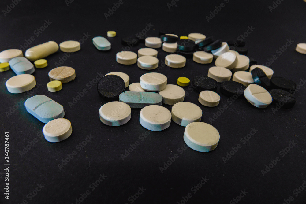 Pile of several medicines on black background