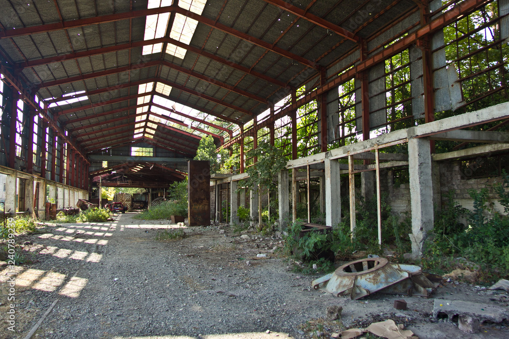 Ruined abandoned industrial building. Overgrown remains of rusty frame Ruined abandoned industrial building. Overgrown remains of rusty frame