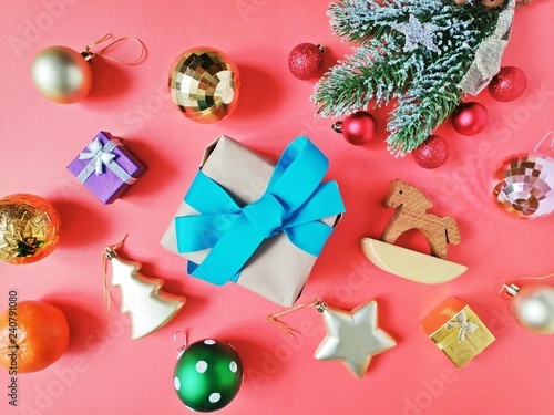 Flat lay Christmas and New Year items. Fir tree branch, shiny ornaments, wrapped gift box and wooden toy horse