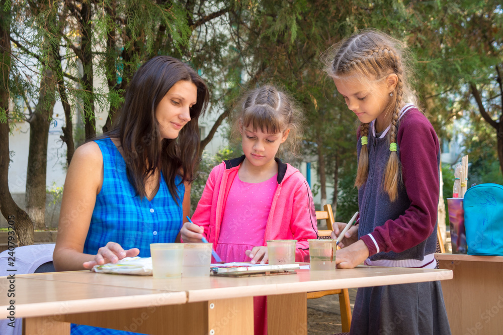 The teacher at the master class gives drawing lessons