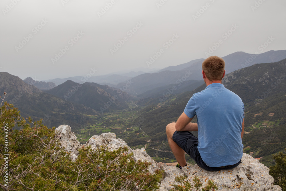 Naklejka premium Person auf einem Felsen, Blick über die Berge