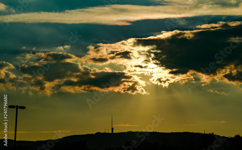 Halos de luz solar al atardecer penetrando entre densas nubes sobre el cielo photo