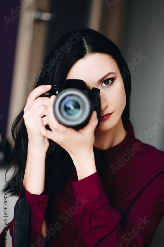 Portrait of young woman taking photo with dslr camera.