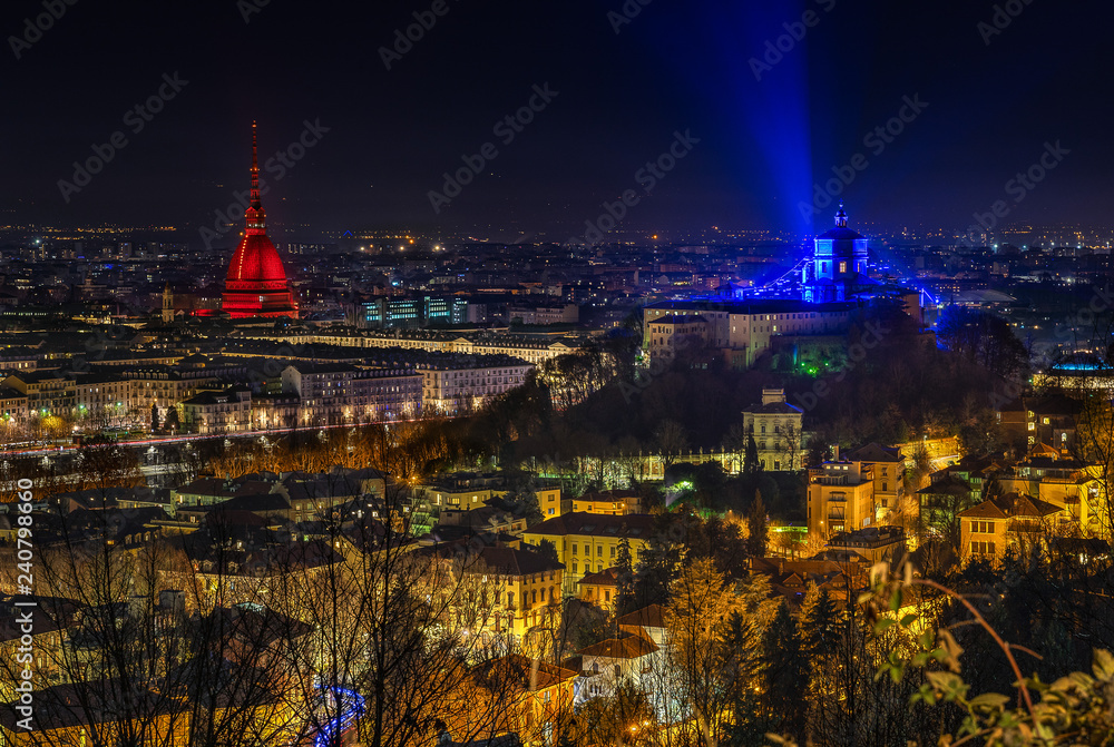 Scenic night cityscape of Turin with the Mole Antonelliana and Monte dei Cappuccini lighted in red and blue, Italy 
