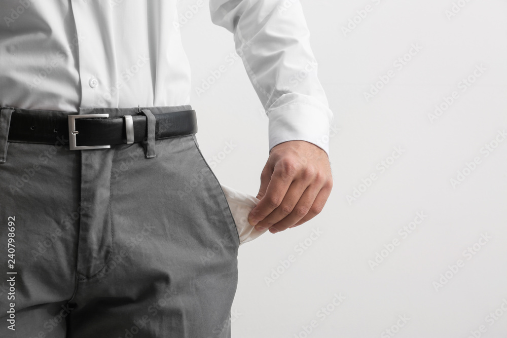 Businessman showing empty pocket on light background, closeup. Space for text