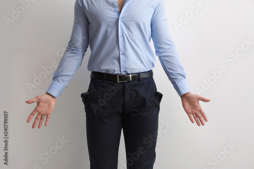 Businessman showing empty pockets on light background, closeup © New Africa