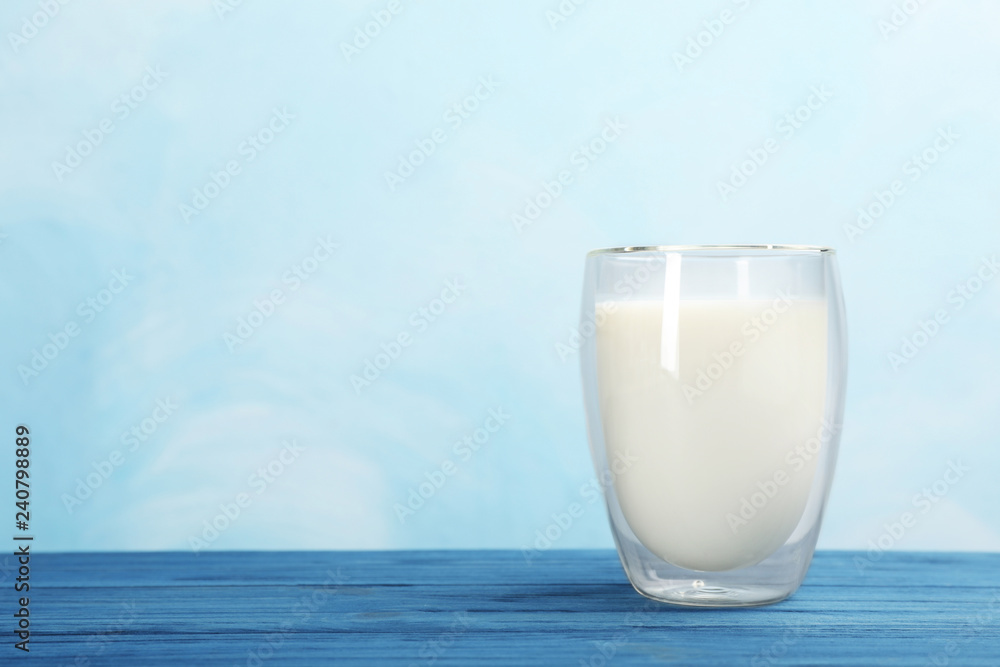 Glass with fresh milk on table against color background. Space for text Glass with fresh milk on table against color background. Space for text