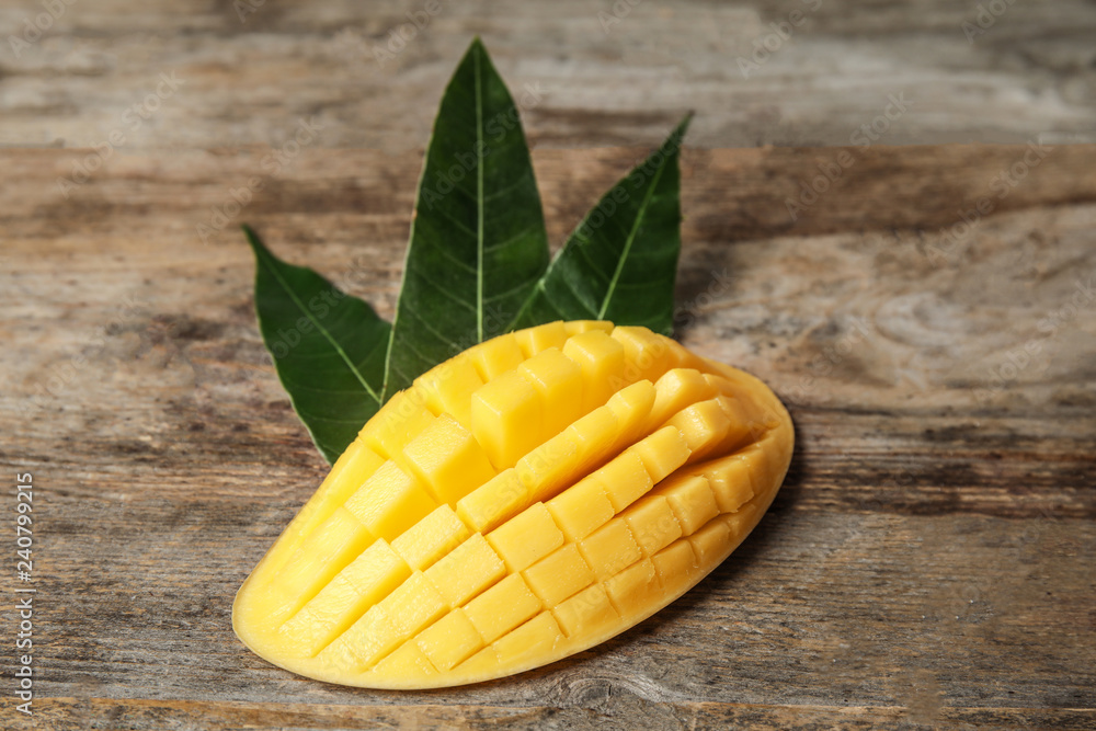 Ripe juicy mango on wooden table. Tropical fruit Ripe juicy mango on wooden table. Tropical fruit