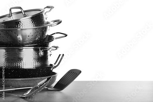 Set of clean cookware and utensils on table against white background, space for text photo