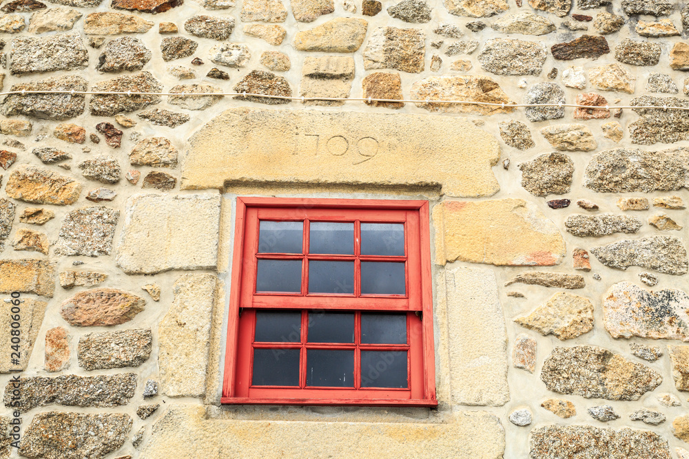 Red guillotine window on a stone framed window