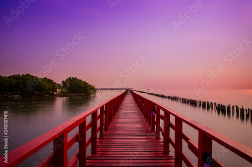 Fototapeta Naklejka Na Ścianę i Meble -  Long Red Bridge sunlight sky tree at beach sea,Red bridge Samut Sakhon Thailand