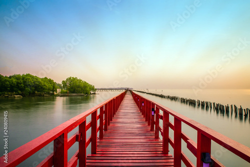 Fototapeta Naklejka Na Ścianę i Meble -  Long Red Bridge sunlight sky tree at beach sea,Red bridge Samut Sakhon Thailand