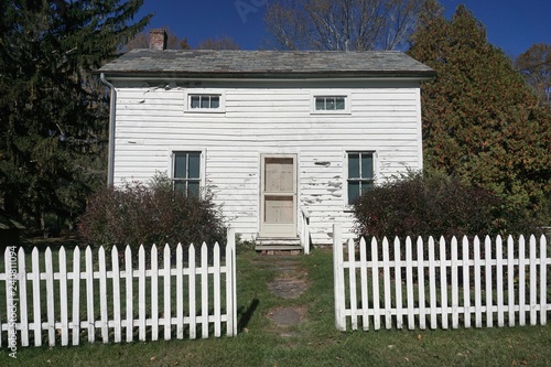 Warren County, New Jersey, USA: An abandoned 19th-century white wooden cottage with white picket fence at Millbrook Village, a historical farming site.