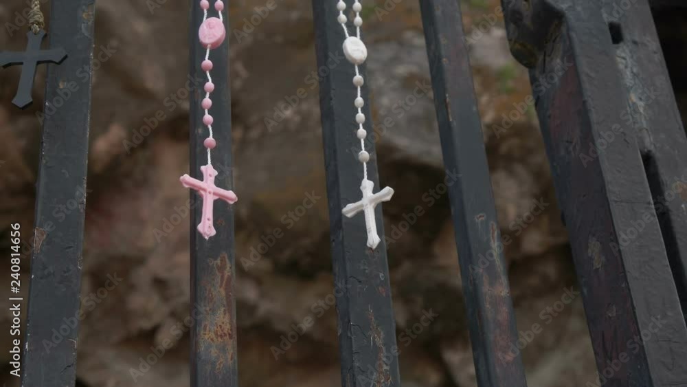 Catholic Rosaries hang on a shrine gate Catholic Rosaries hang on a shrine gate