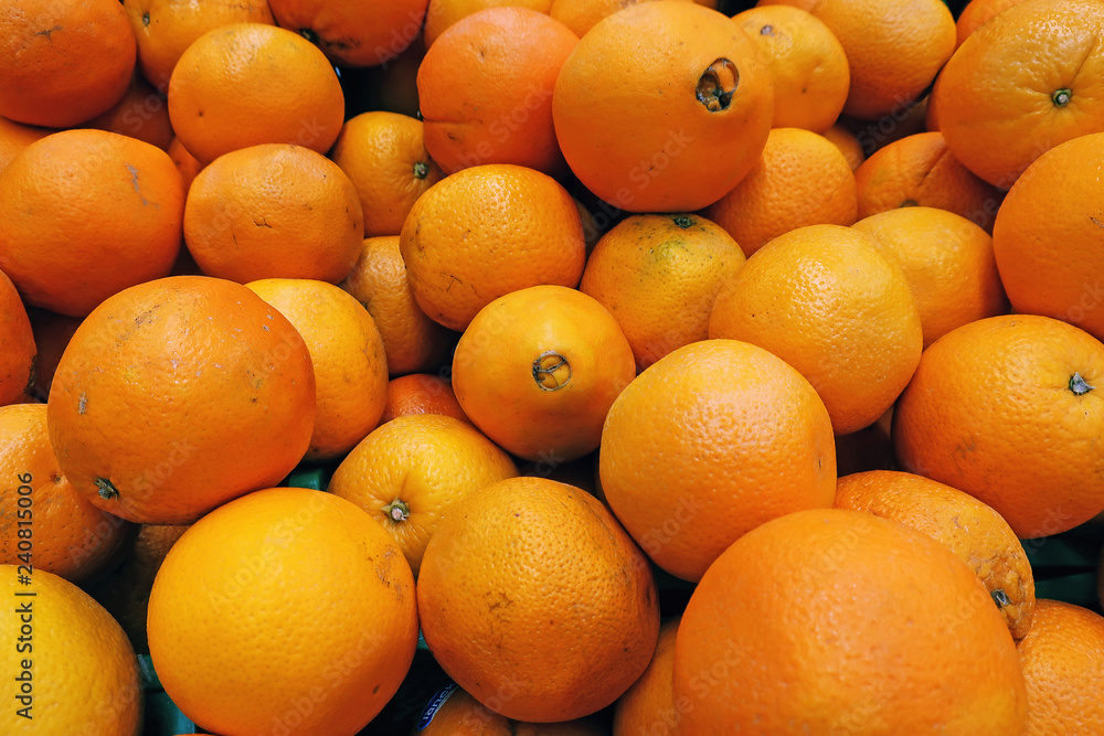 scattered ripe yellow juicy oranges on the counter in the market