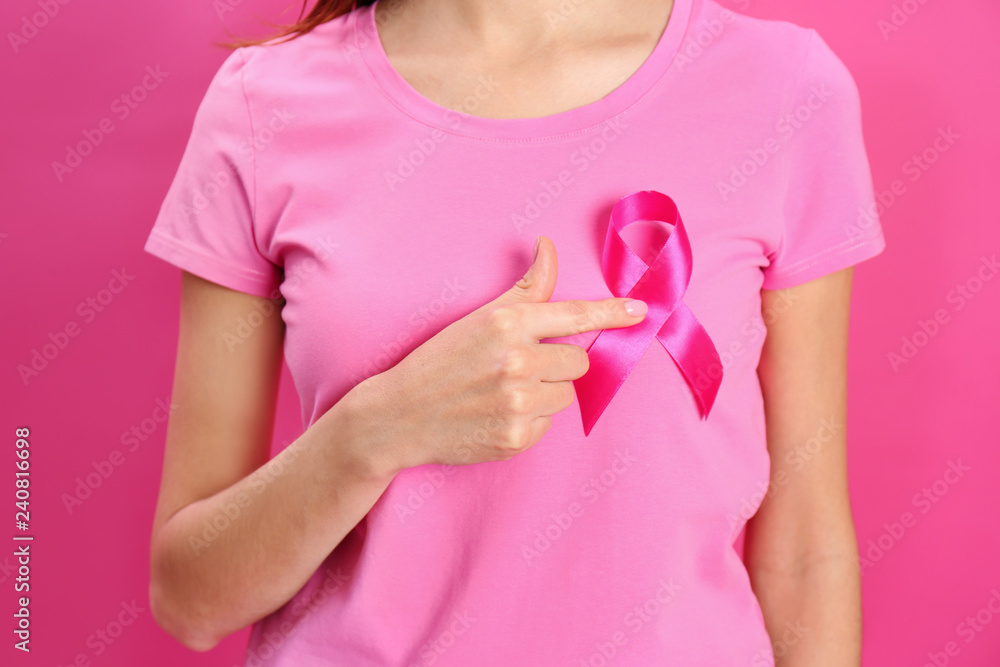Woman with pink ribbon on color background, closeup. Breast cancer awareness Woman with pink ribbon on color background, closeup. Breast cancer awareness