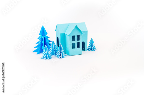 Blue house glued out of paper stands in the Violet forest.