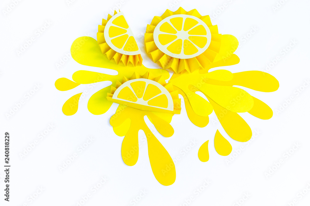 Yellow lemon with splashes made of paper on a white background. Fruit smoothies vegetarian.