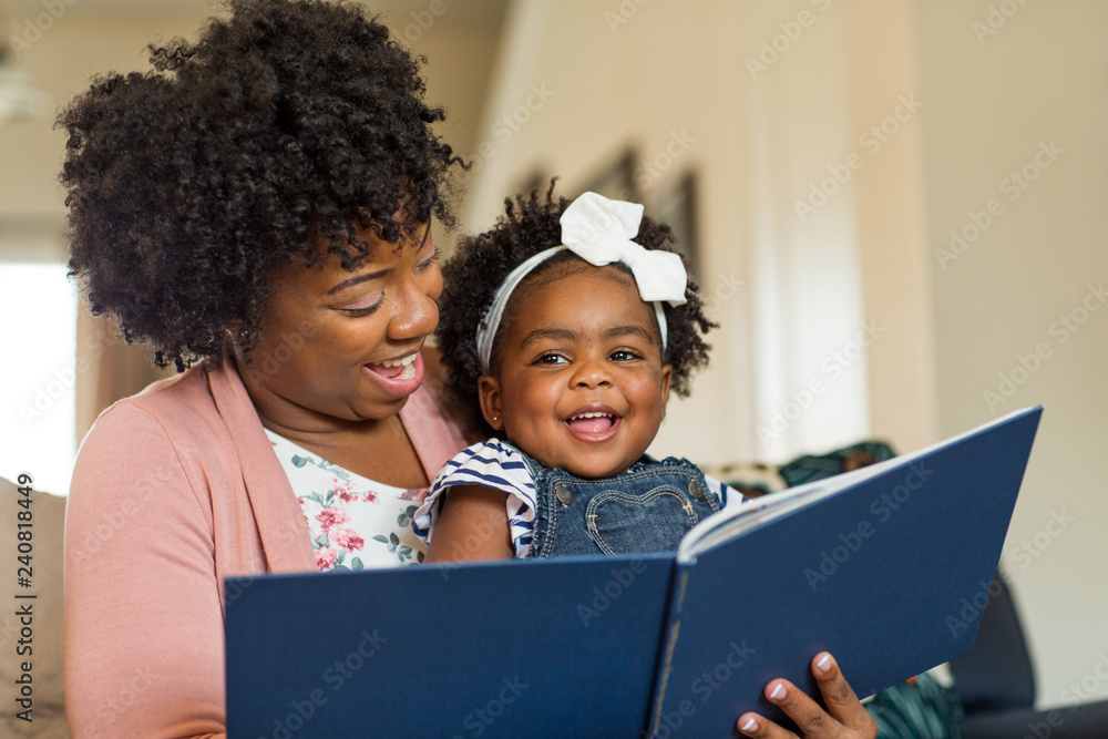 Mother reading a book to her little girl.