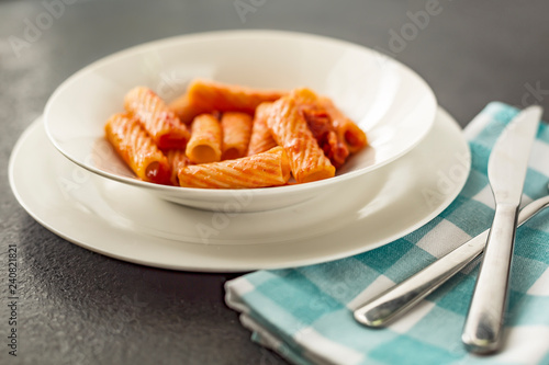 Penne Amatriciana fresh pasta with parmesan cheese on dark backg