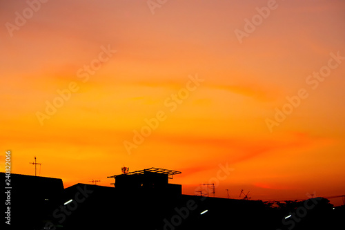 Beautiful light of Sunset with clouds in the sky reflection behind the building.