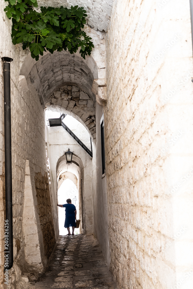 Italian woman standing in narrow alley in old village