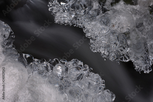 Detail of ice in river. Bright reflections in icicles