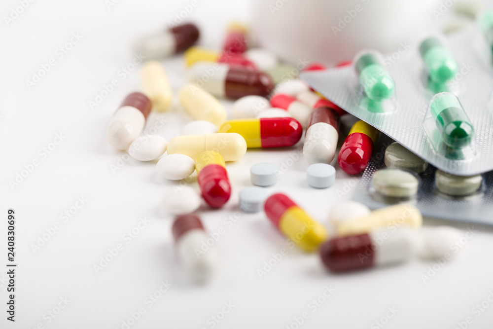 Medicine pills, tablets and capsules over white background