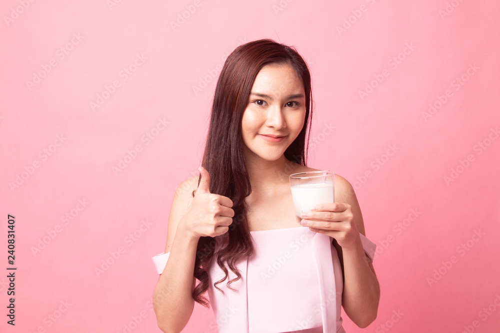 Healthy Young Asian woman drinking milk show thumb up Healthy Young Asian woman drinking milk show thumb up