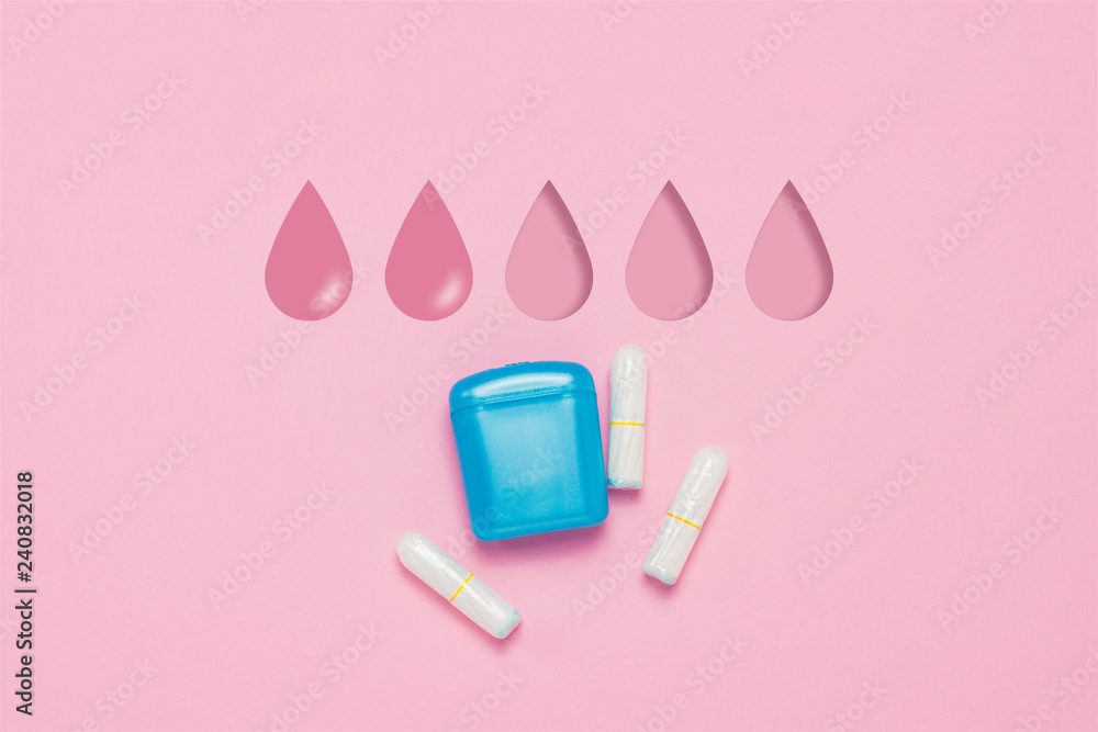 Feminine hygiene tampons and box for shipping and storage on a pink background. Concept of feminine hygiene during menstruation. Added drop mark, absorption level. Two drops. Flat lay, top view Feminine hygiene tampons and box for shipping and storage on a pink background. Concept of feminine hygiene during menstruation. Added drop mark, absorption level. Two drops. Flat lay, top view