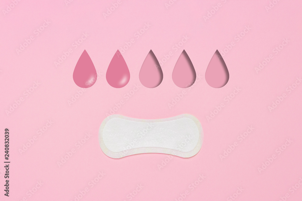 Feminine hygiene pad on a pink background. Concept of feminine hygiene during menstruation. Added drop mark, absorption level. two drops. Flat lay, top view Feminine hygiene pad on a pink background. Concept of feminine hygiene during menstruation. Added drop mark, absorption level. two drops. Flat lay, top view