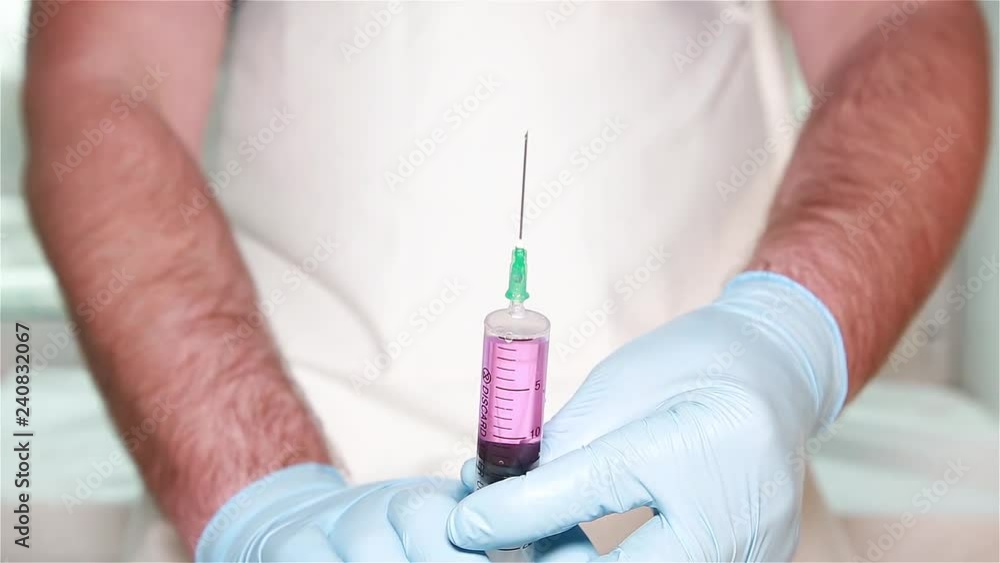 A man prepares a syringe for injection A man prepares a syringe for injection