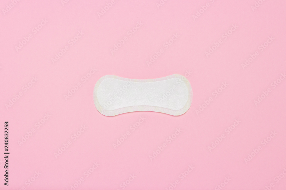 Feminine hygiene pad on a pink background. Concept of feminine hygiene during menstruation. Flat lay, top view Feminine hygiene pad on a pink background. Concept of feminine hygiene during menstruation. Flat lay, top view