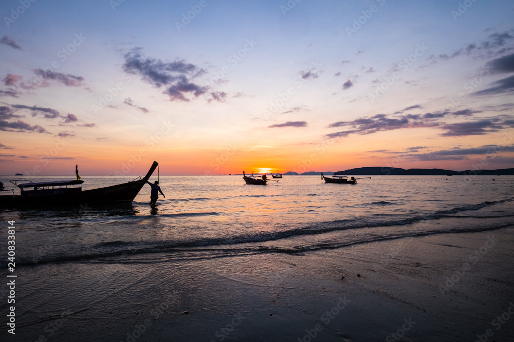 Man pulling boat across the beach