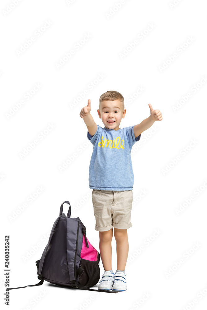 Full length portrait of cute little kid boy in stylish clothes looking at camera and smiling, standing against white studio wall. Kids fashion concept Full length portrait of cute little kid boy in stylish clothes looking at camera and smiling, standing against white studio wall. Kids fashion concept