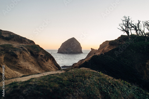 large rock at beach during sunset