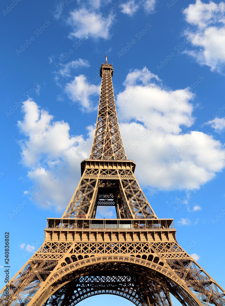 great Eiffel Tower with blue sky and white clouds in vertical