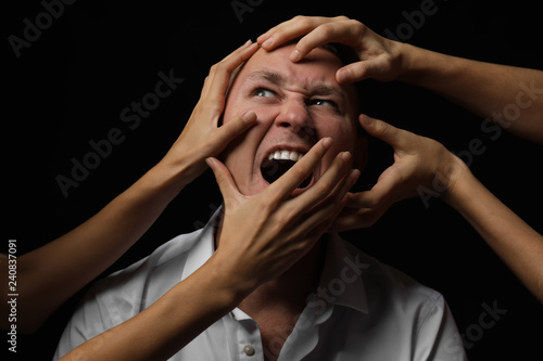 Many hands stretched to man...