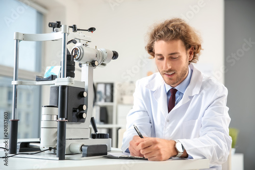 Portrait of young ophthalmologist in office