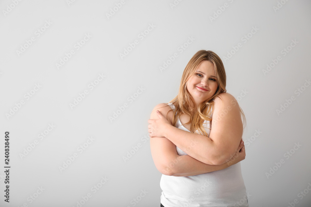 Beautiful plus size girl on light background. Concept of body positivity Beautiful plus size girl on light background. Concept of body positivity