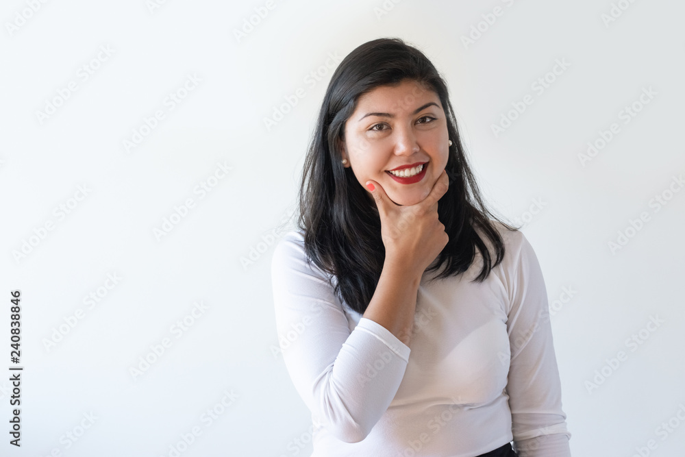 Cheerful young woman thinking over decision. Young mix raced girl leaning chin on hand and smiling at camera. Decision making concept Cheerful young woman thinking over decision. Young mix raced girl leaning chin on hand and smiling at camera. Decision making concept