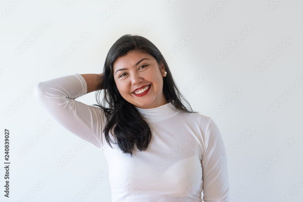 Happy cheerful mix raced girl expressing joy. Positive young woman keeping hand on nap and laughing at camera. Positive emotions and joy concept Happy cheerful mix raced girl expressing joy. Positive young woman keeping hand on nap and laughing at camera. Positive emotions and joy concept
