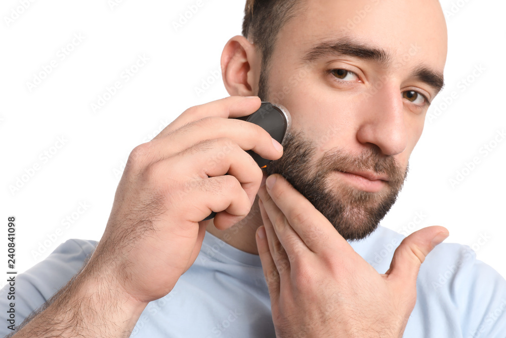 Handsome man using electric shaver against white background