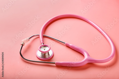 Medical stethoscope on coral background