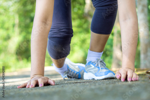 female falling while running in a park, sport injury accident concept 