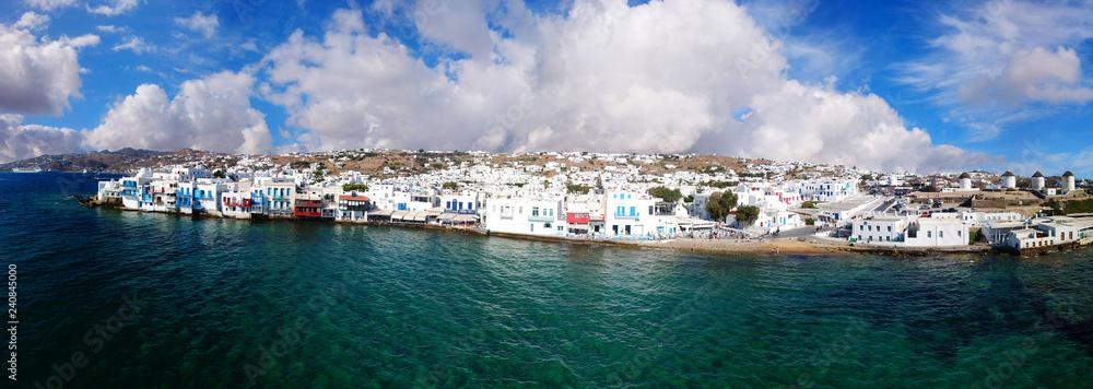 Aerial drone panoramic view of beautiful and popular Mykonos town with stunning clouds, Cyclades, Greece