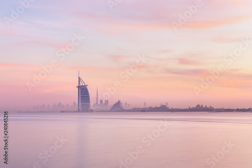 Canvas Print Stunning view of Dubai skyline from Jumeirah beach to Downtown lighted with warm pastel sunrise colors