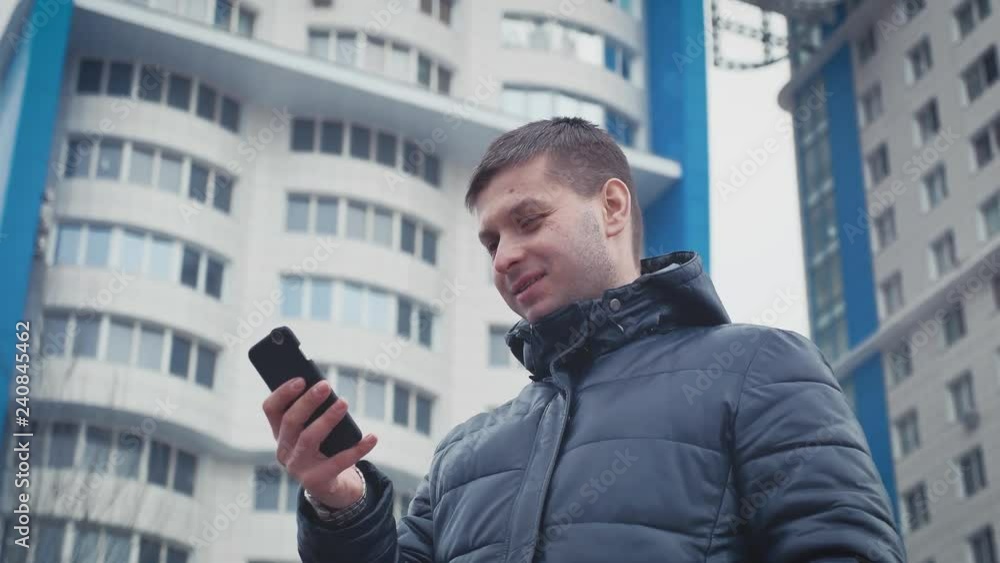 Urban businessman talking on smartphone on the street, businessman thinks. Urban businessman talking on smartphone on the street, businessman thinks.