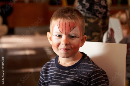 Boy face with red colors on his face, facepainting watercolor/